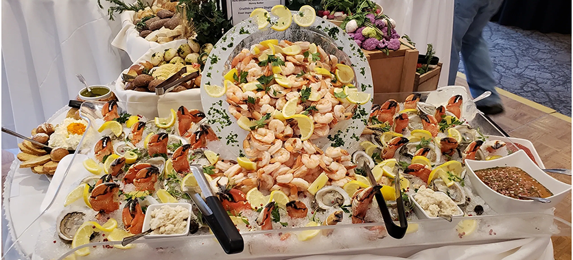 A seafood platter with shrimp, lemon slices, and shellfish arranged on ice.