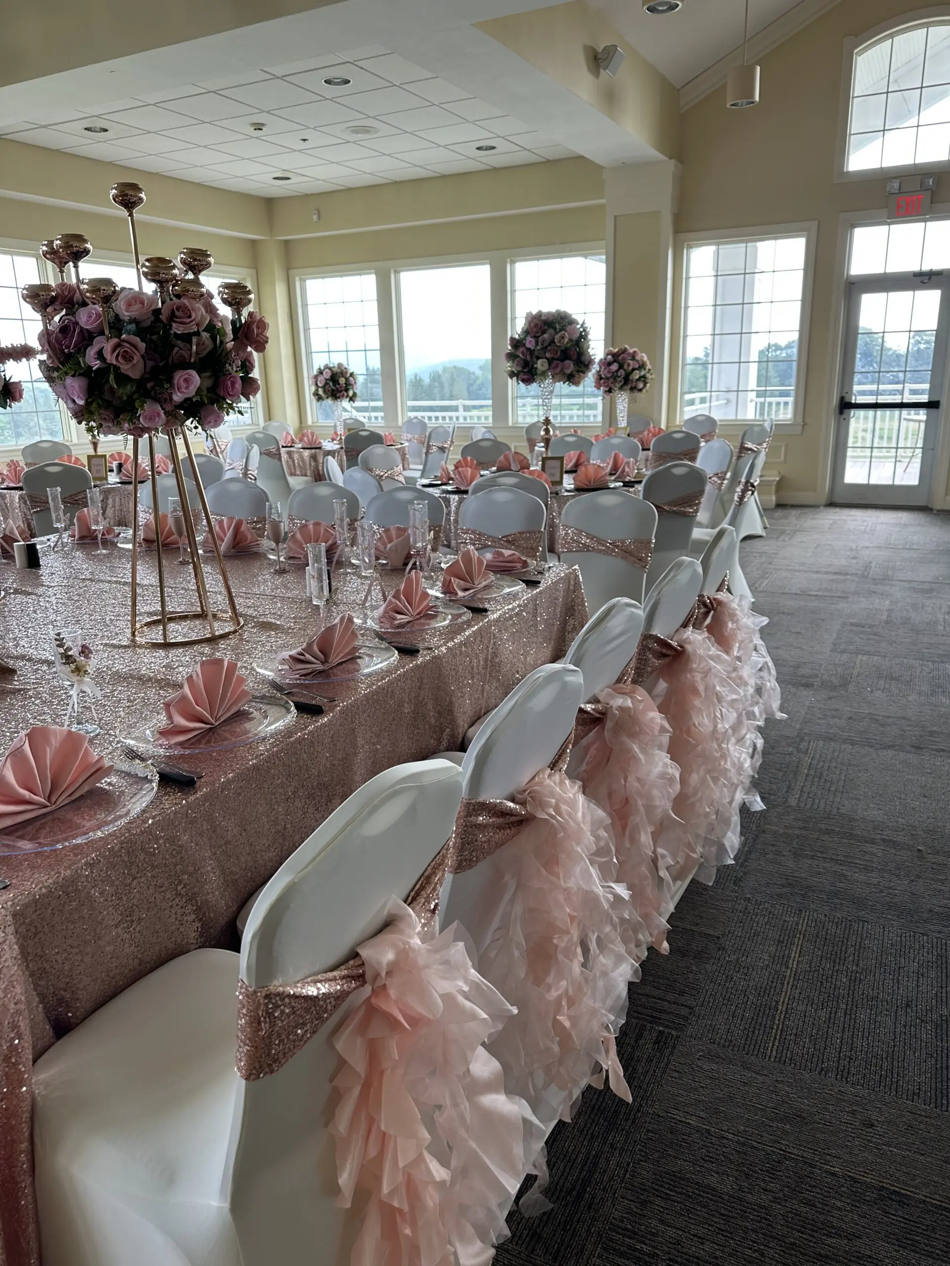 Elegant wedding reception setup with pink and white decorations.