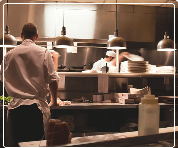 Chefs working in a busy restaurant kitchen preparing food.