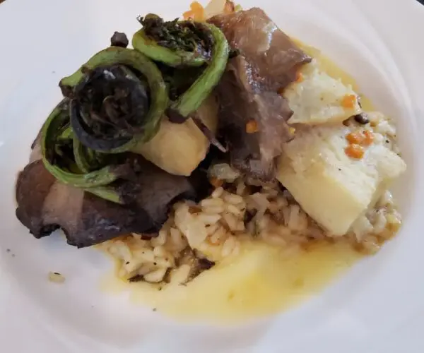A plate with cooked meat, grilled vegetables, and scrambled eggs.
