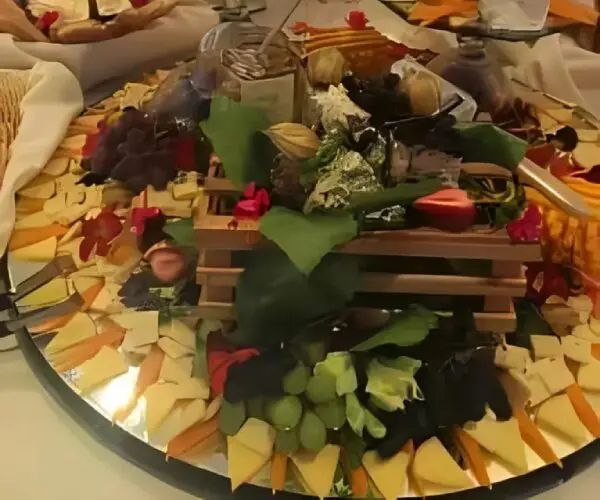 A rustic cheese and charcuterie board with assorted fruits and crackers.