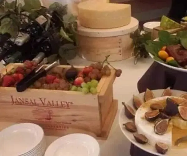 A wooden crate with skewers of meat and vegetables at a buffet.