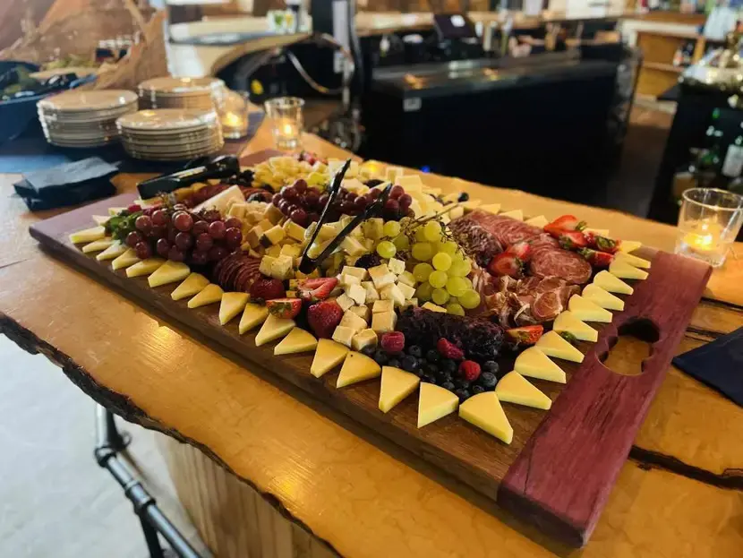 A charcuterie board with meats, cheeses, and fruits.
