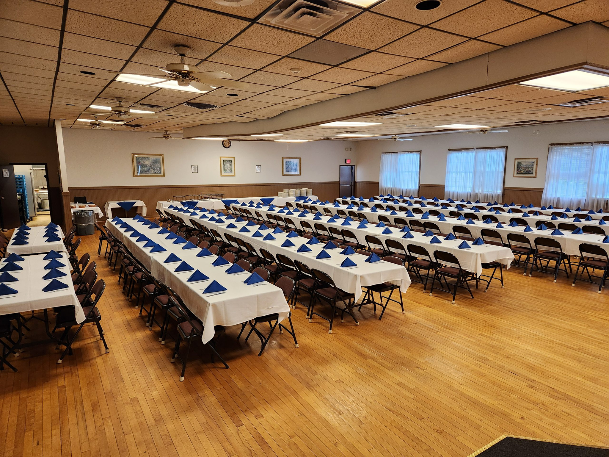 A large banquet hall set with long tables and chairs for an event.