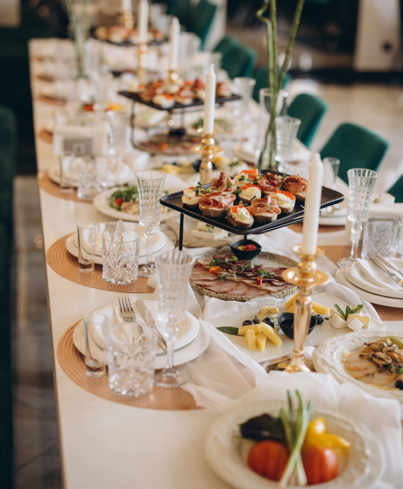 Elegant table setting with tiered trays of appetizers and drinks.