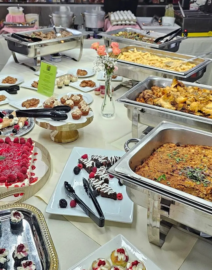 A buffet table with various dishes and desserts.